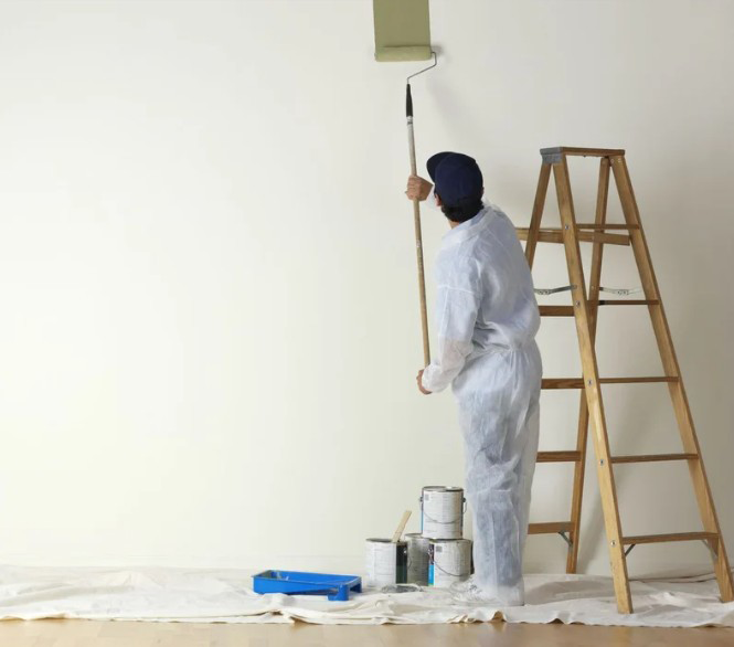 Pintor treballant a l'interior d'un habitatge